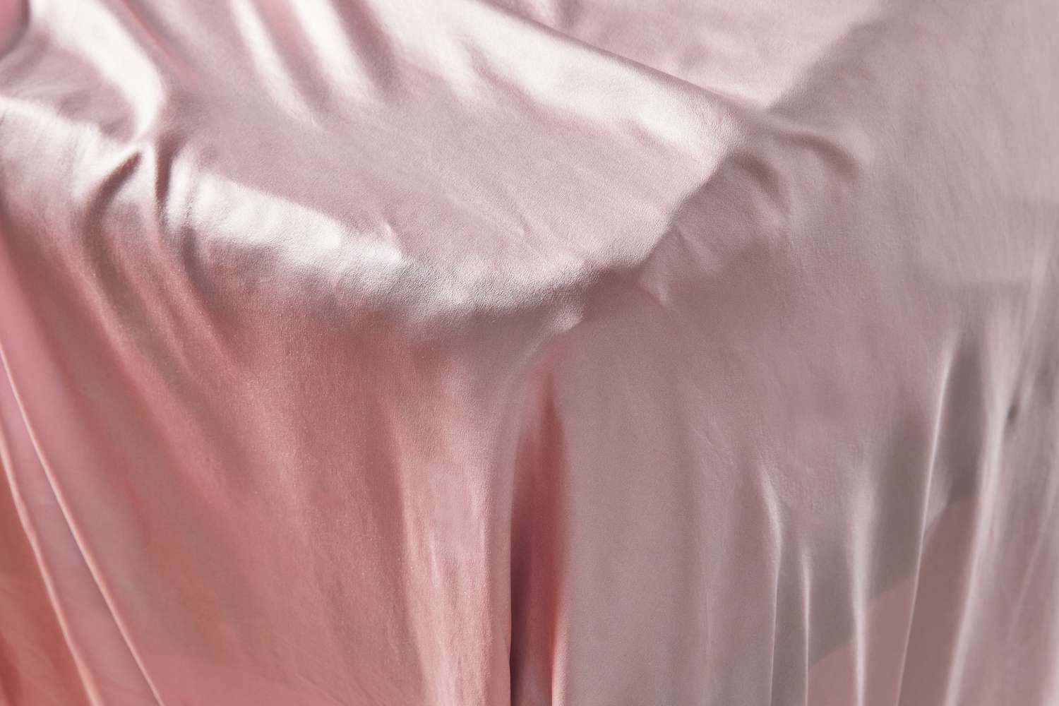Closeup of the Lilysilk 19 Momme Seamless Silk Sheets Set on the corner of a bed 