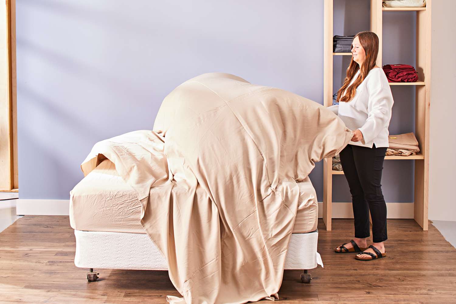 Person holding a Cozy Earth Bamboo Sheet Set top sheet over the mattress