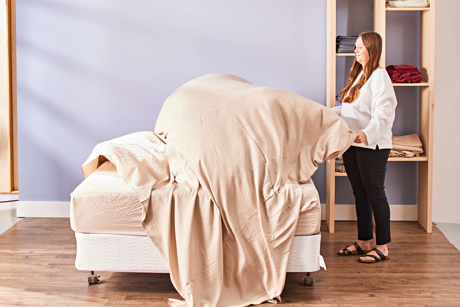 A woman folding the Cozy Earth Bamboo Sheet Set