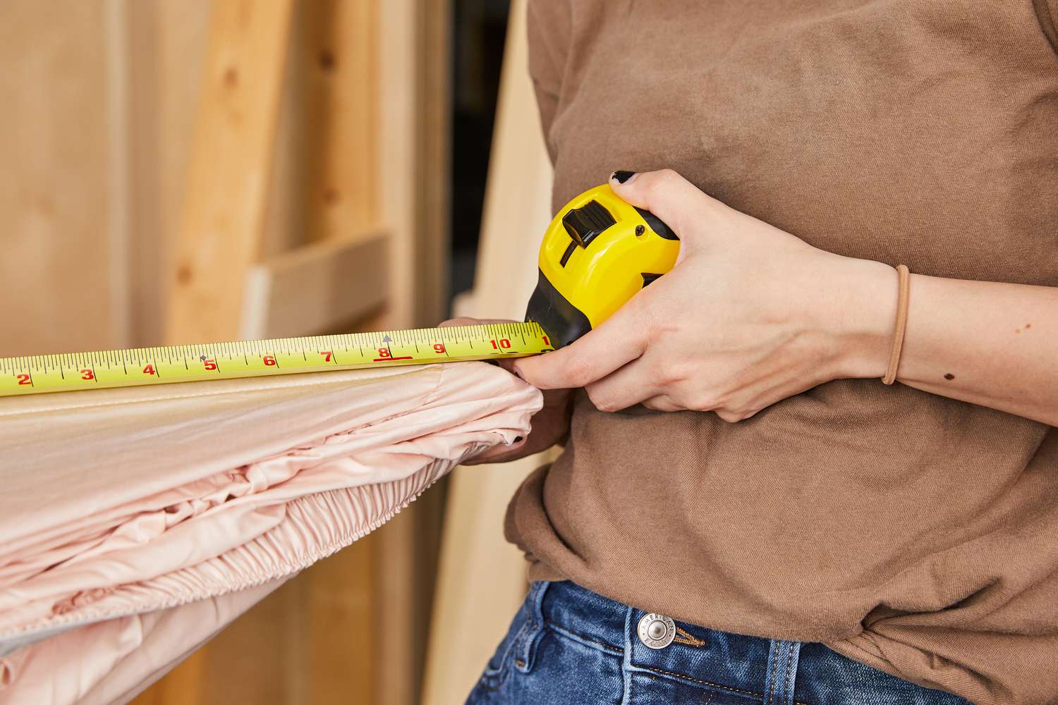 Person holding measuring tape over a Linenwalas 100% Tencel Lyocell fitted sheet