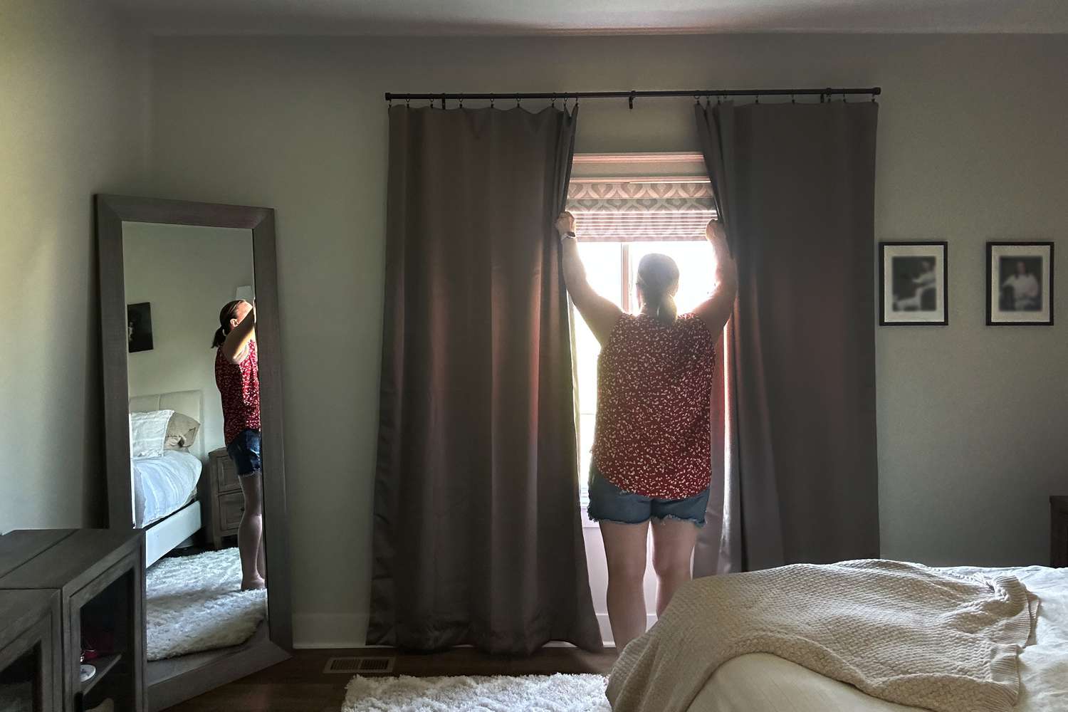 A person opening the Sun Zero Oslo Blackout Curtains. 