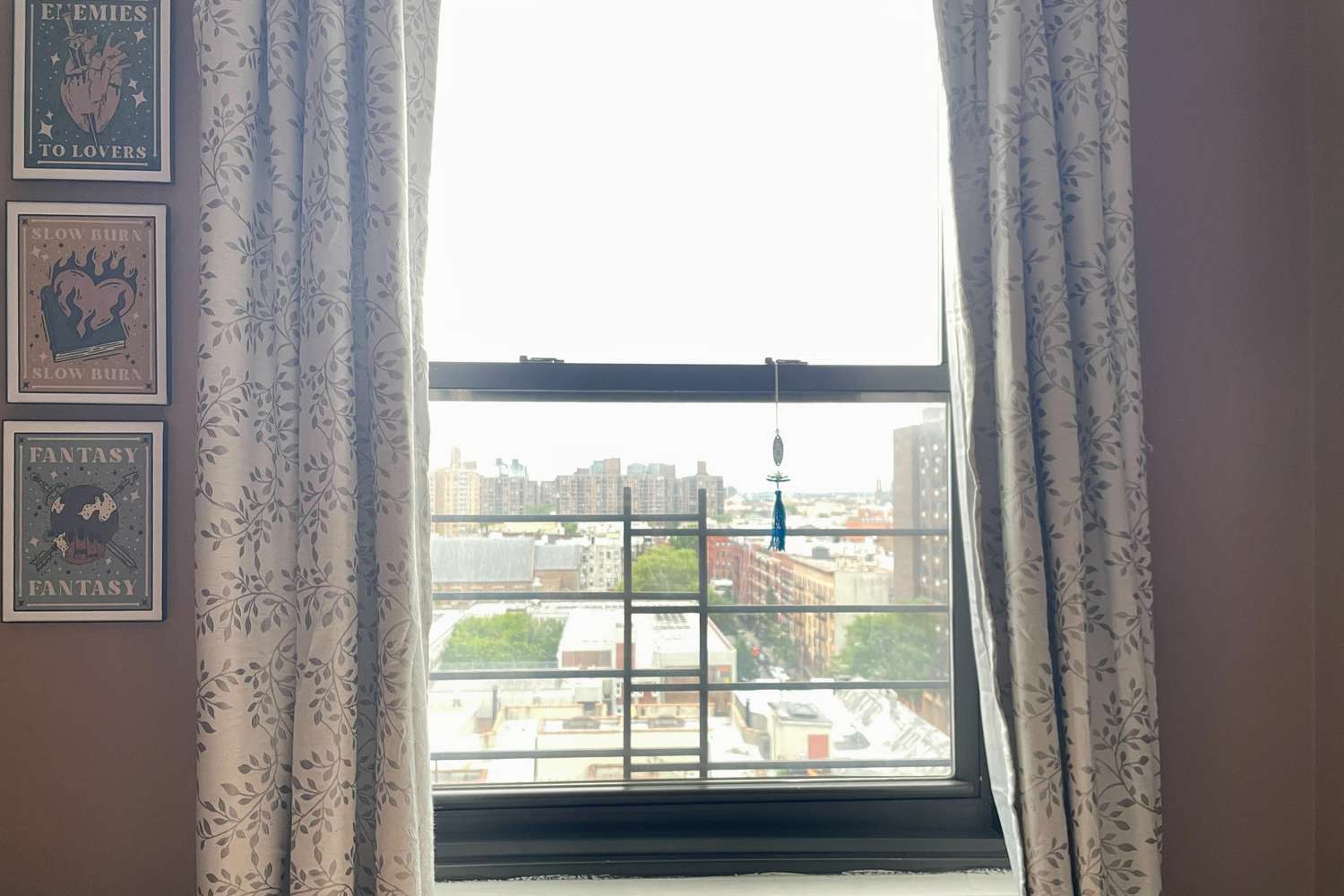 The Better Homes & Gardens Rod Pocket Blackout Curtains pulled open with the view of a city outside.