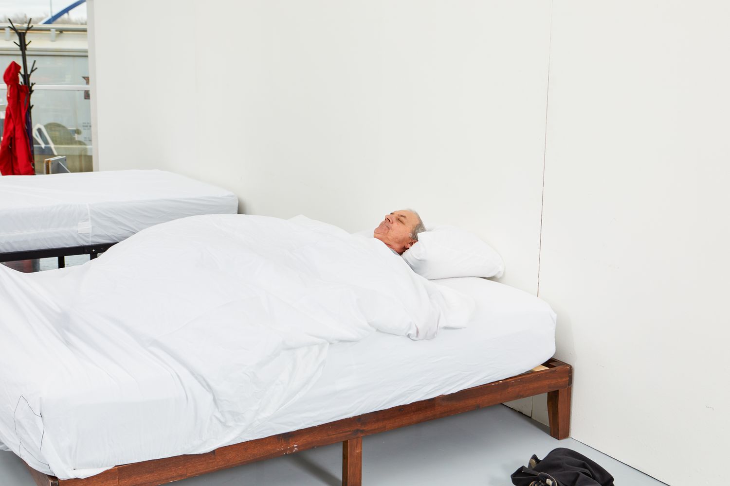 Person sleeping on bed made up with Boll & Branch Reserve Sheet Set