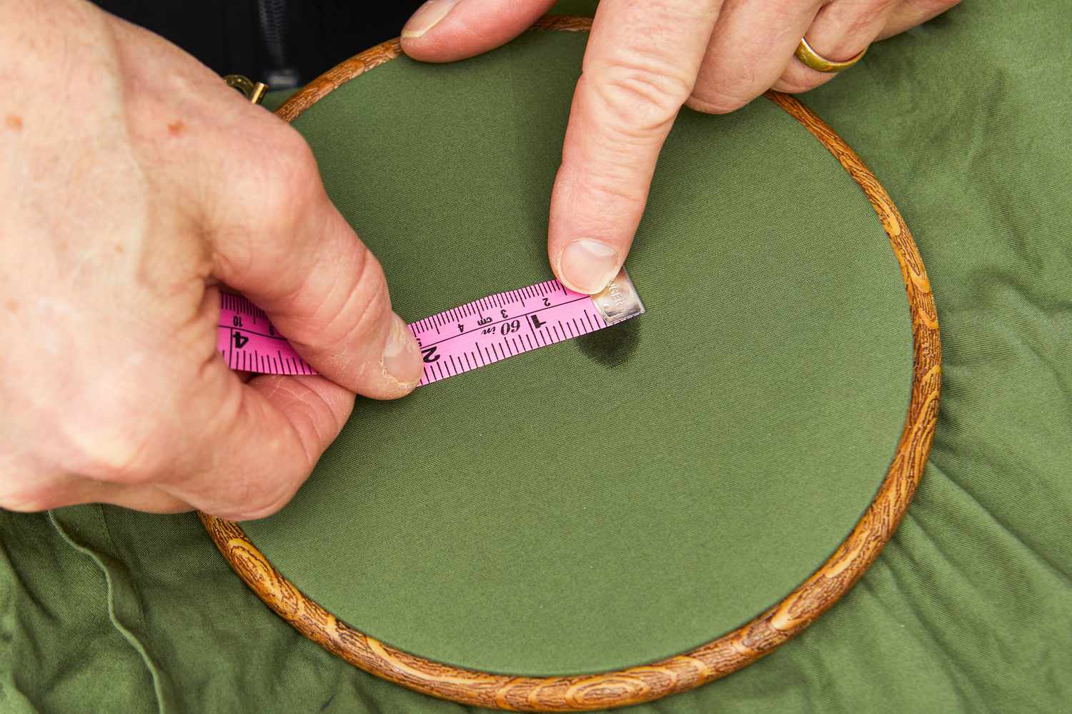 Person measuring the stain on Nest Bedding Sateen Organic Cotton Sheet Set with measuring tape 