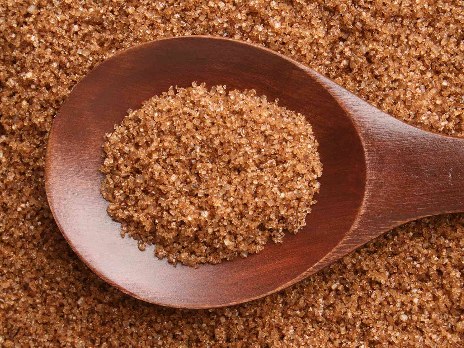 Top view of wooden spoon full of brown sugar