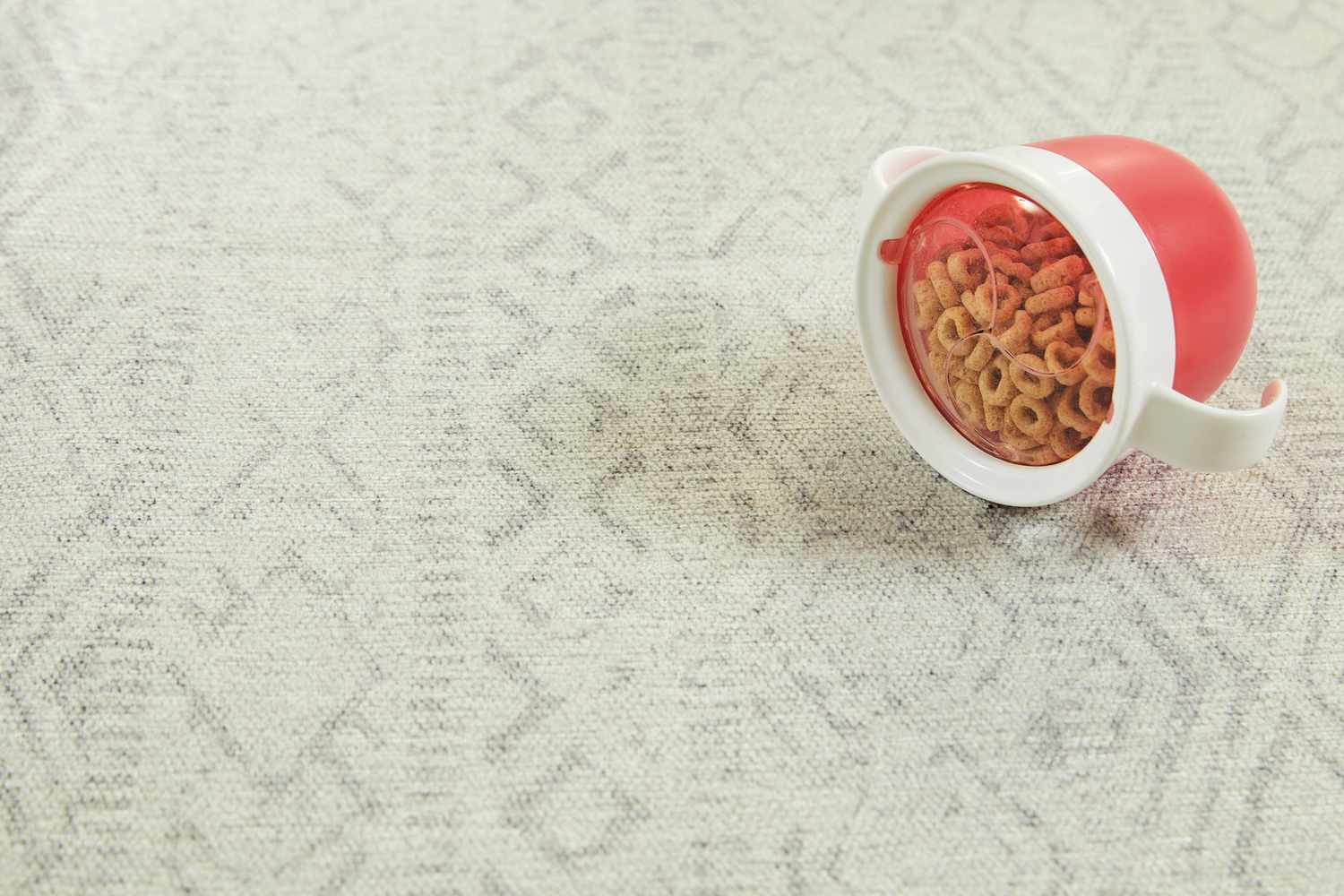 Close up of a small cup filled with cereal on top of the Tumble Tabor Washable Rug that has a Cushioned Rug Pad