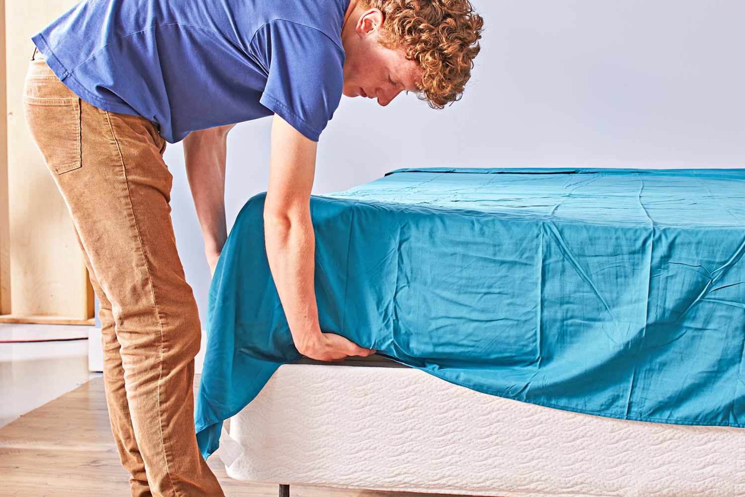 A person fixing a bed using the Cosy House Collection Luxury Bamboo Sheets