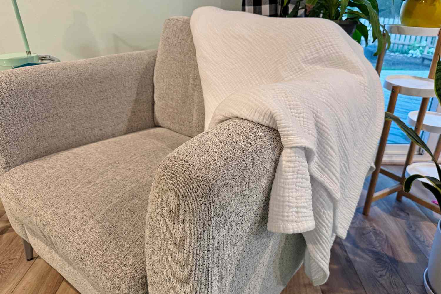 The Bedsure 100% Cotton Muslin Throw Blanket folded on a chair