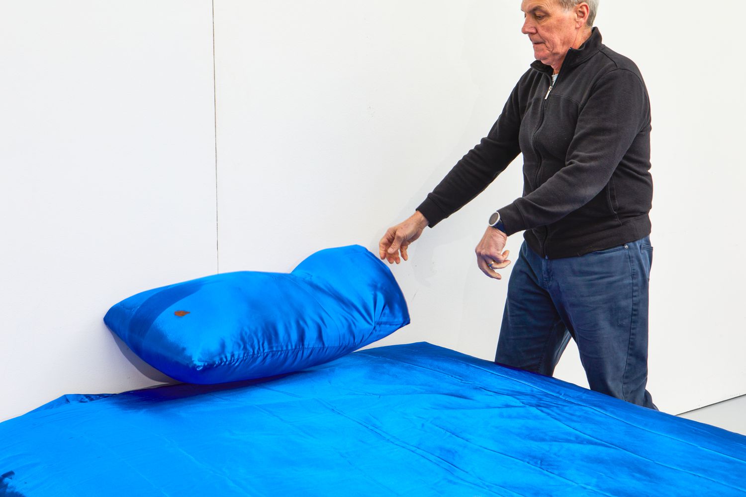 Person placing pillow covered in Decolure Satin pillow cover on bed